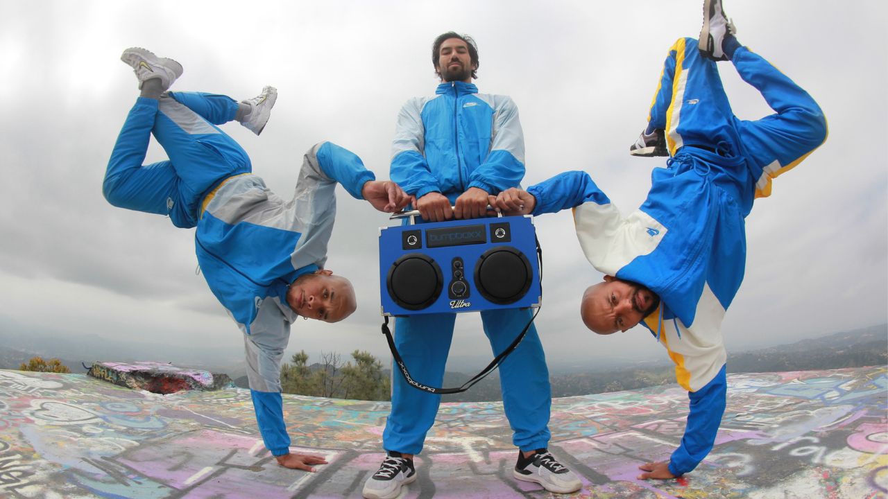 THEULTRABOYS performing handstands alongside their blue boombox